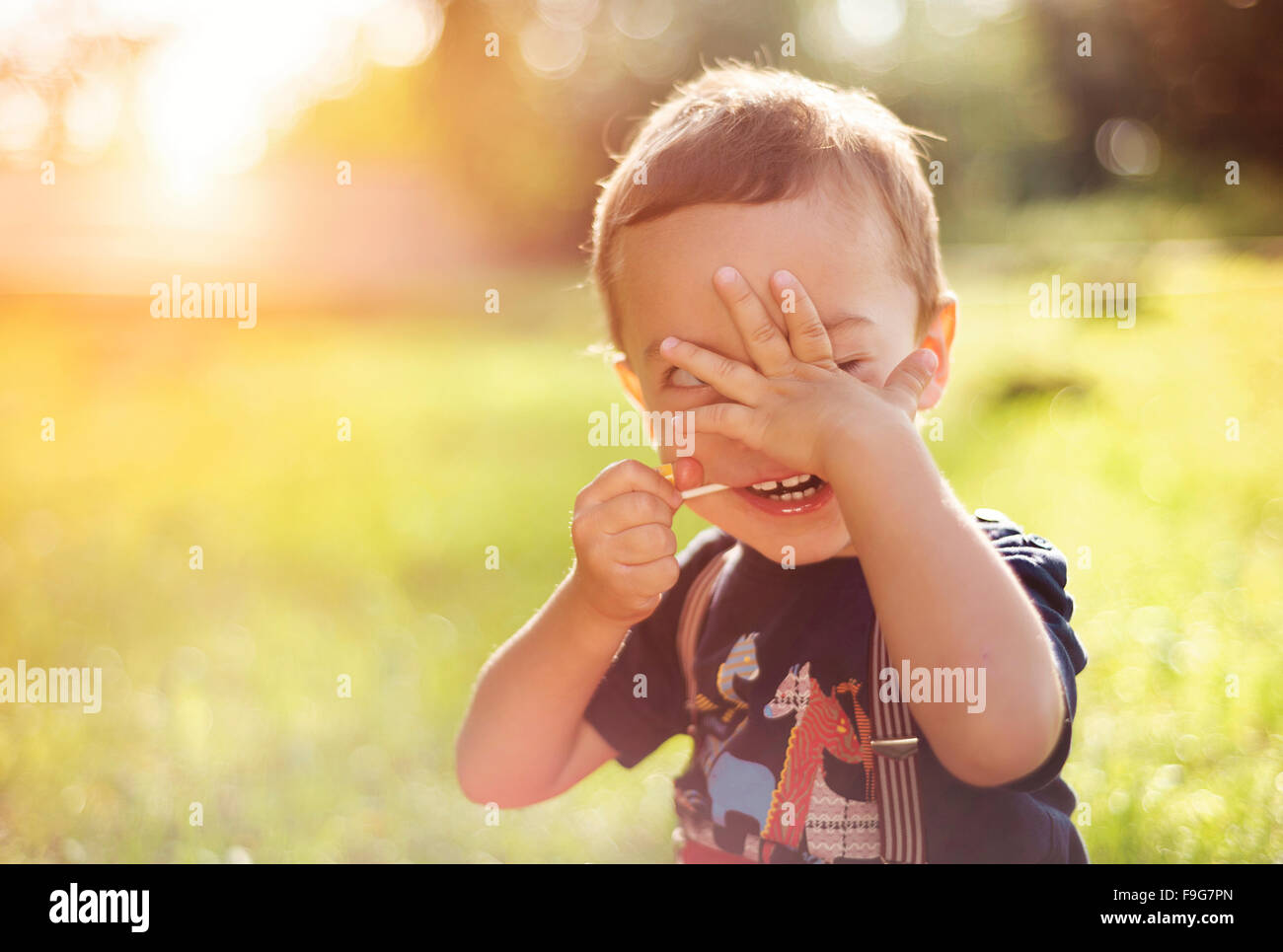 Cute little boy having fun outside in summer nature Stock Photo