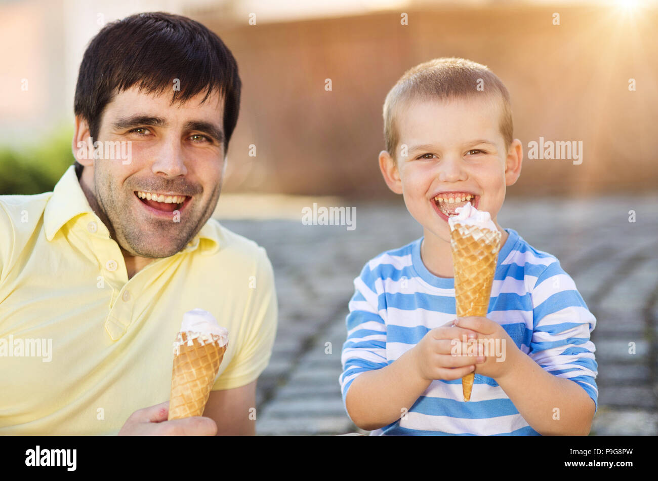 Father and son enjoying ice cream outside in a park Stock Photo Alamy
