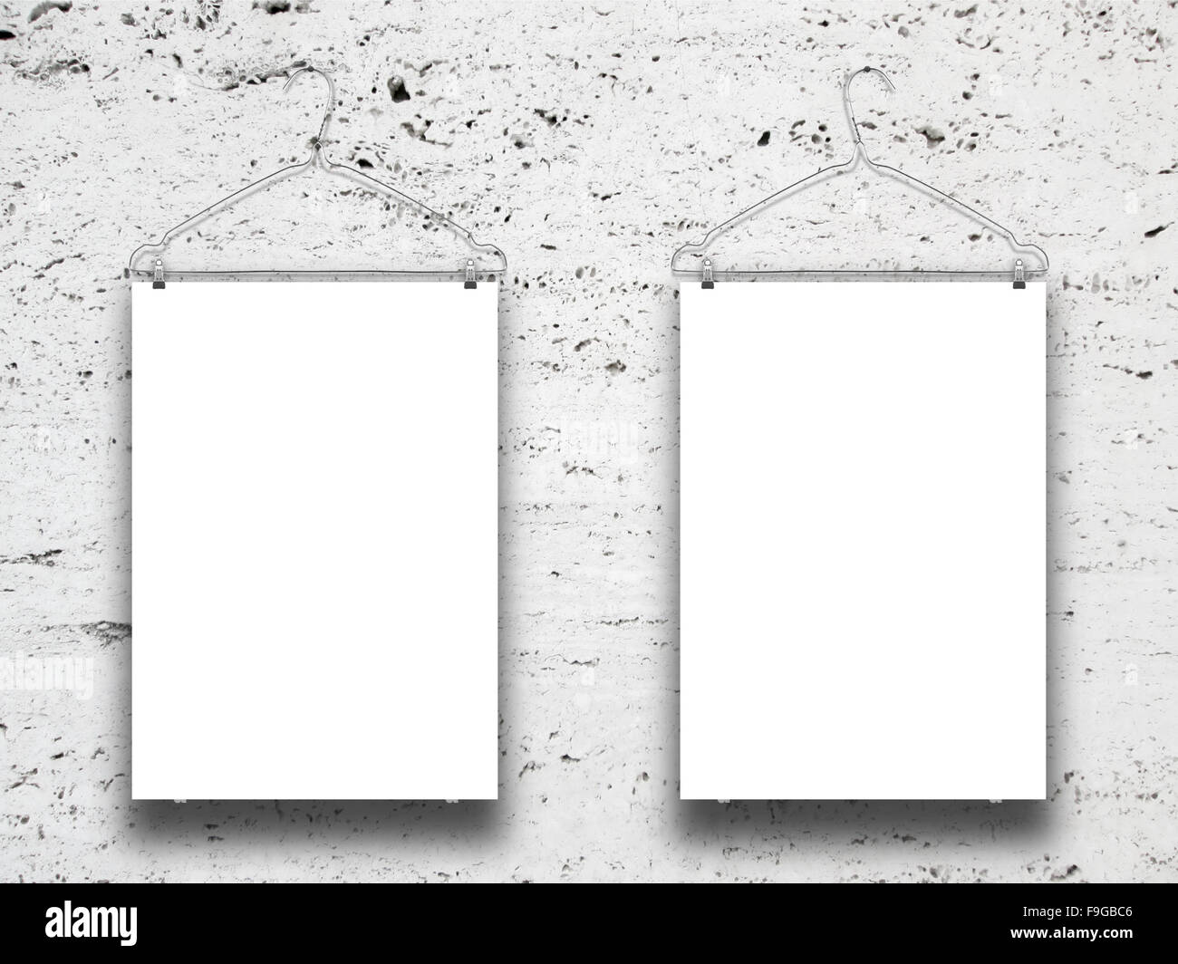 Close-up of white paper sheet frames with clothes-hanger on white marble wall background Stock Photo
