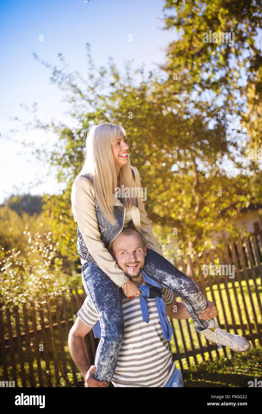 Happy young couple having fun outside in a park Stock Photo - Alamy