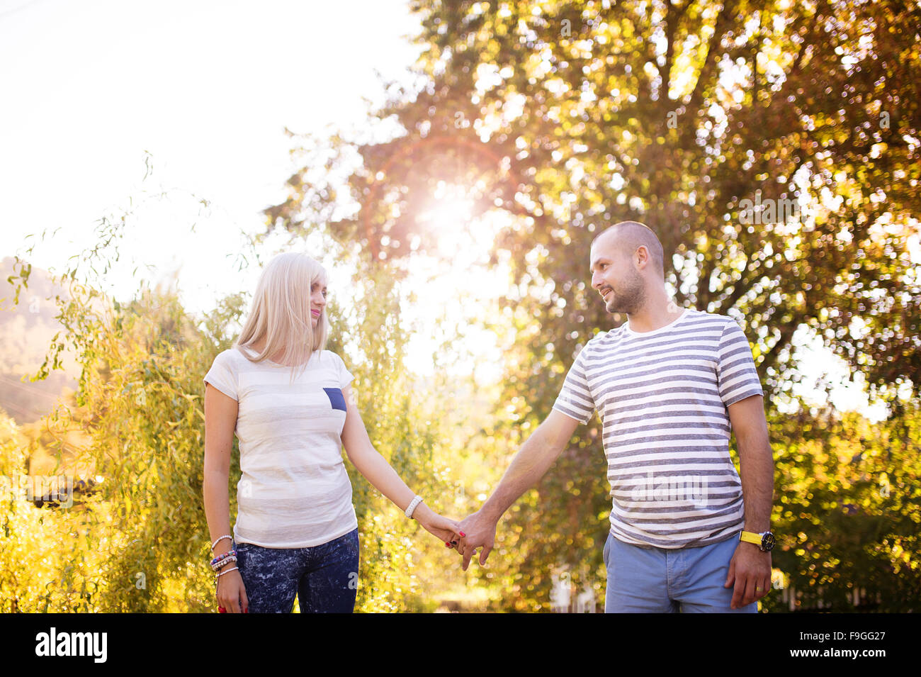 Happy young couple having fun outside in a park Stock Photo - Alamy