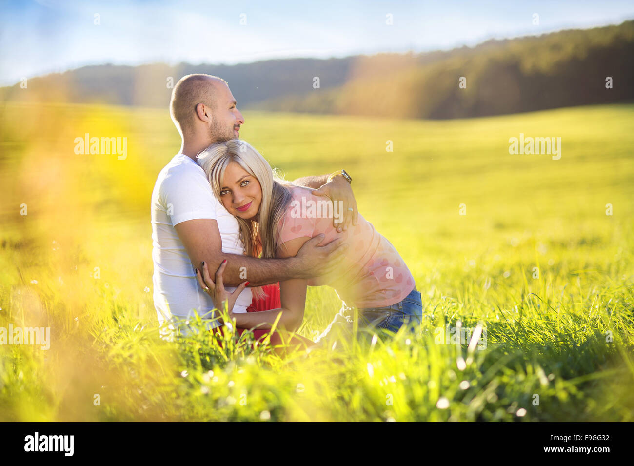 Happy young couple in love hugging and kissing outside in a park Stock ...