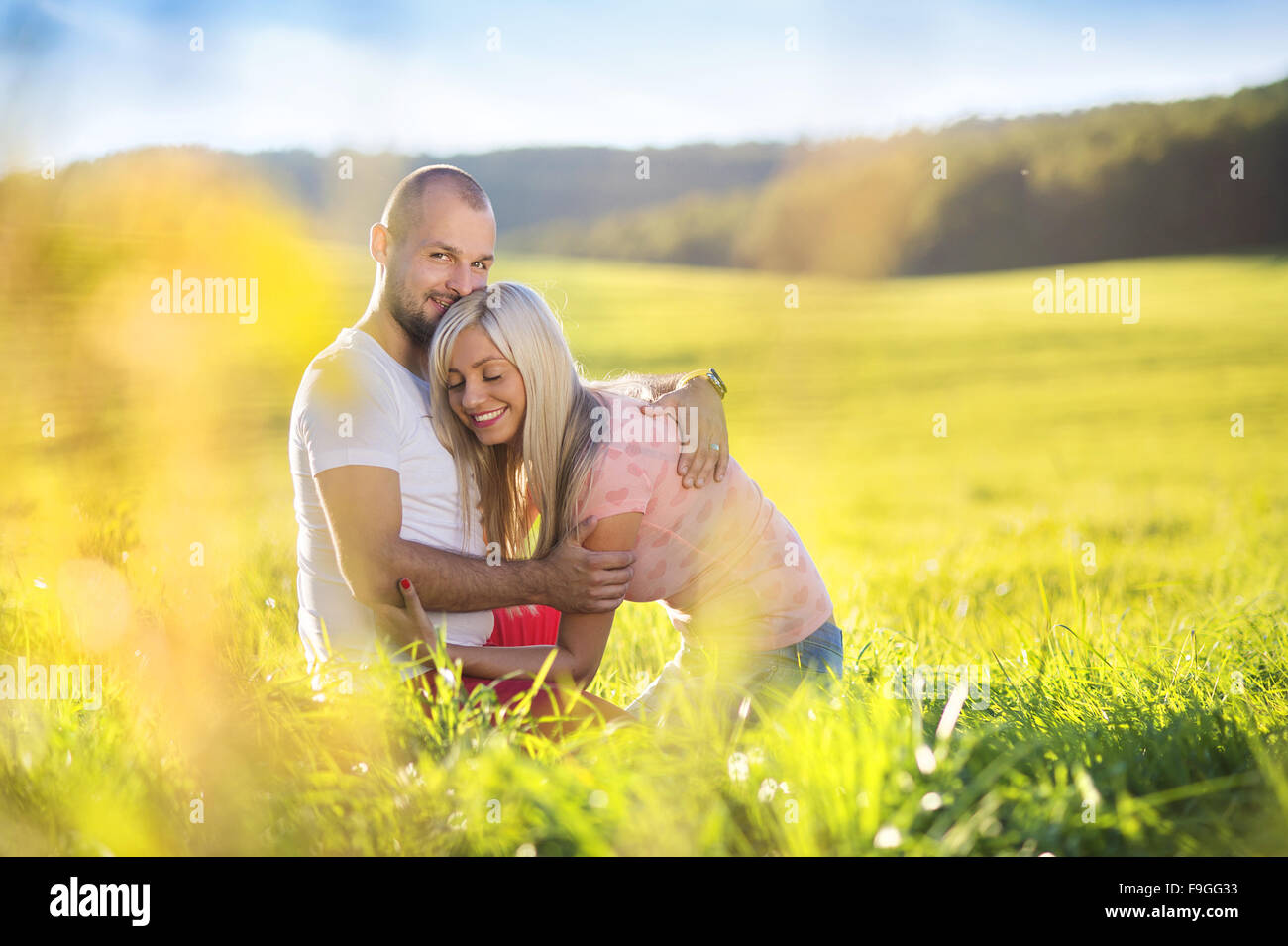 Happy young couple in love hugging and kissing outside in a park Stock ...