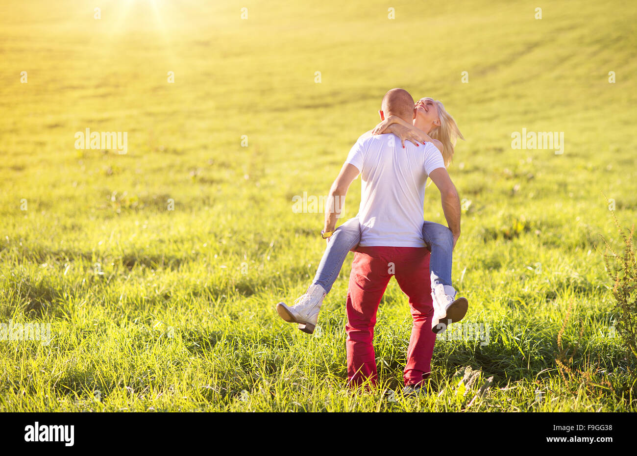 Happy young couple having fun outside on a meadow Stock Photo - Alamy
