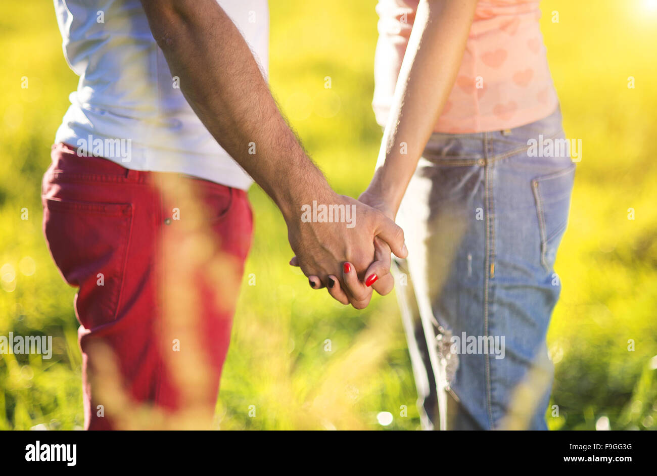 Holding hands of happy young couple having fun outside in a park Stock ...