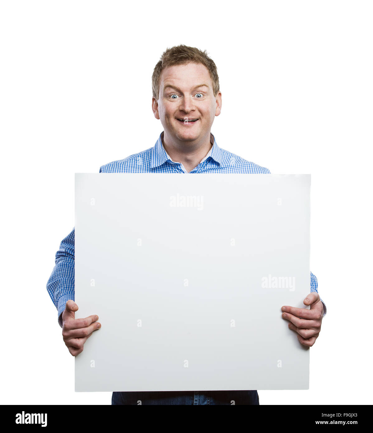 Young man making funny face, holding a blank sign board. Studio shot on white background. Stock Photo