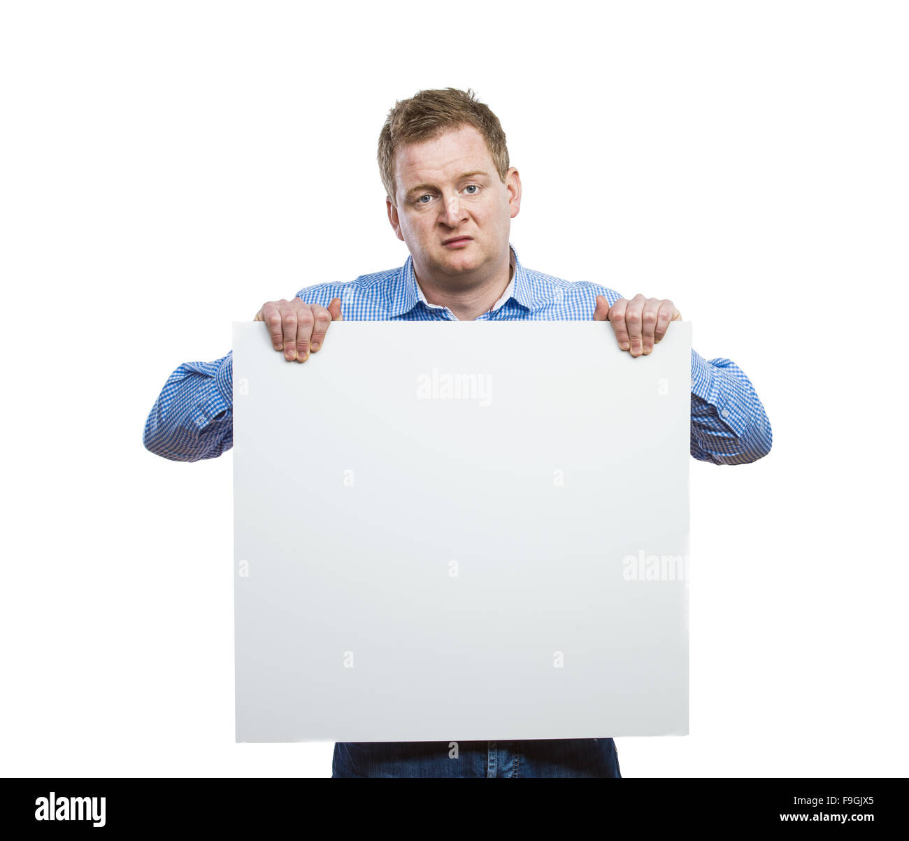 Young man making funny face, holding a blank sign board. Studio shot on white background. Stock Photo