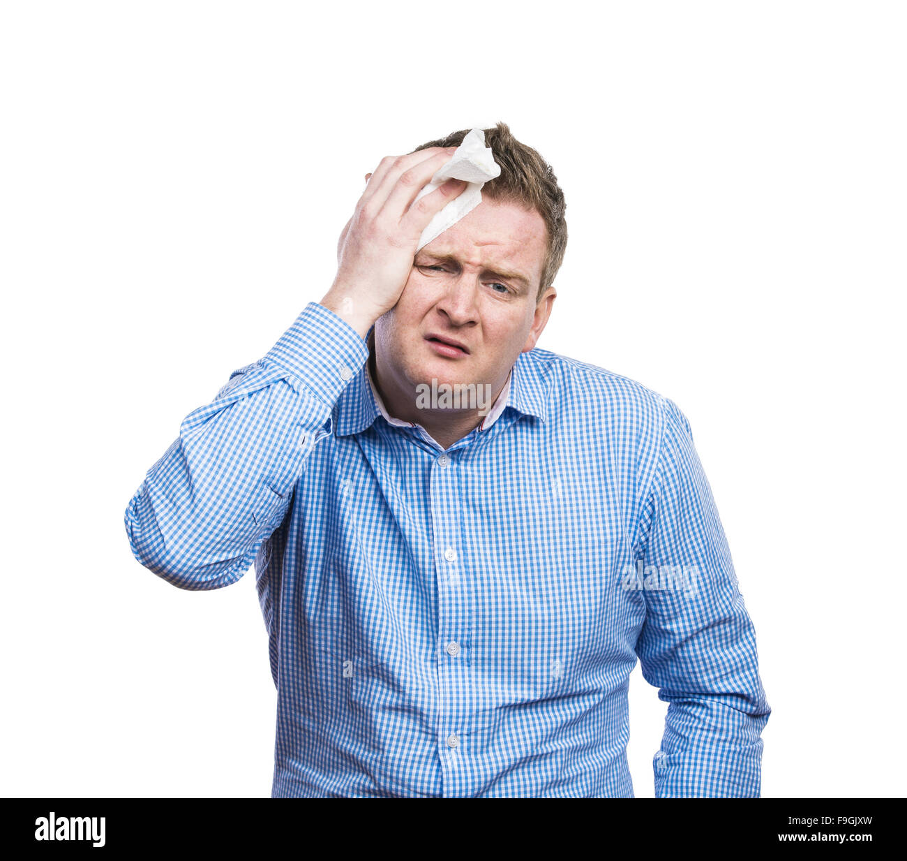 Funny young drunk man with headache. Studio shot on white background. Stock Photo
