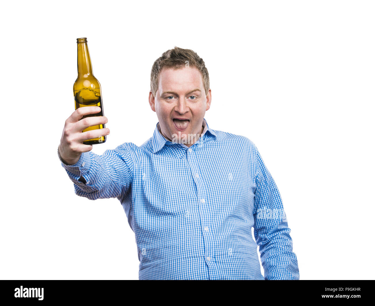 Funny young drunk man holding a beer bottle. Studio shot on white background. Stock Photo