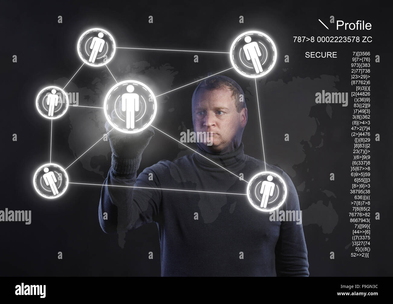 Thief in action stealing information with balaclava on his face, dressed in black. Studio shot on black background. Stock Photo