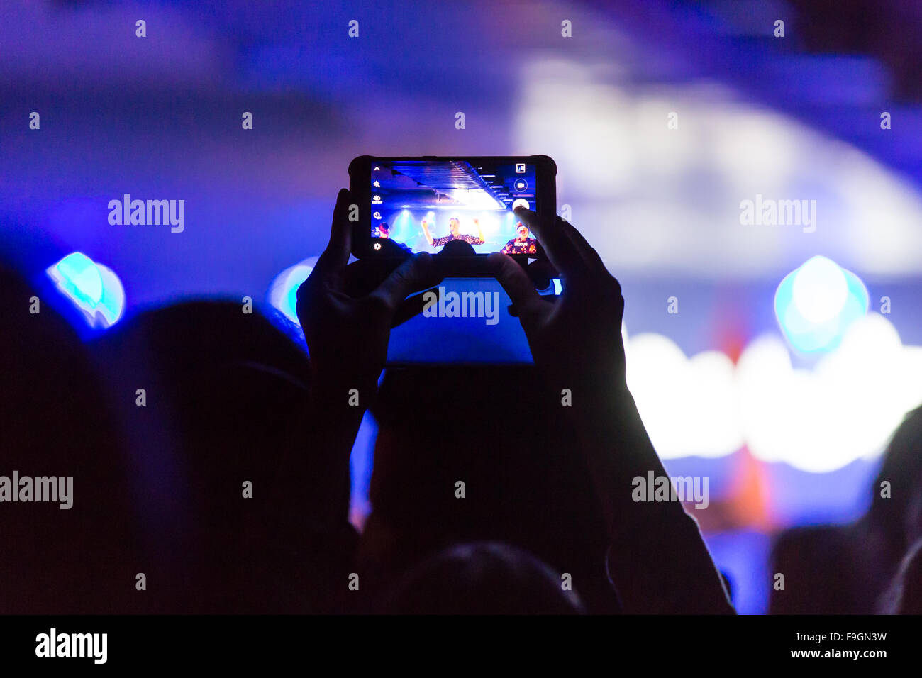 Concert-goer taking photo with iPhone Stock Photo
