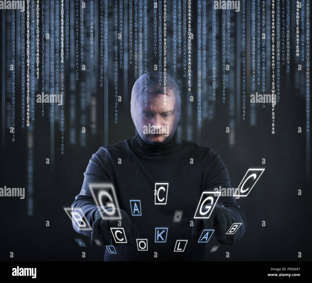 Thief in action stealing information with balaclava on his face, dressed in black. Studio shot on black background. Stock Photo