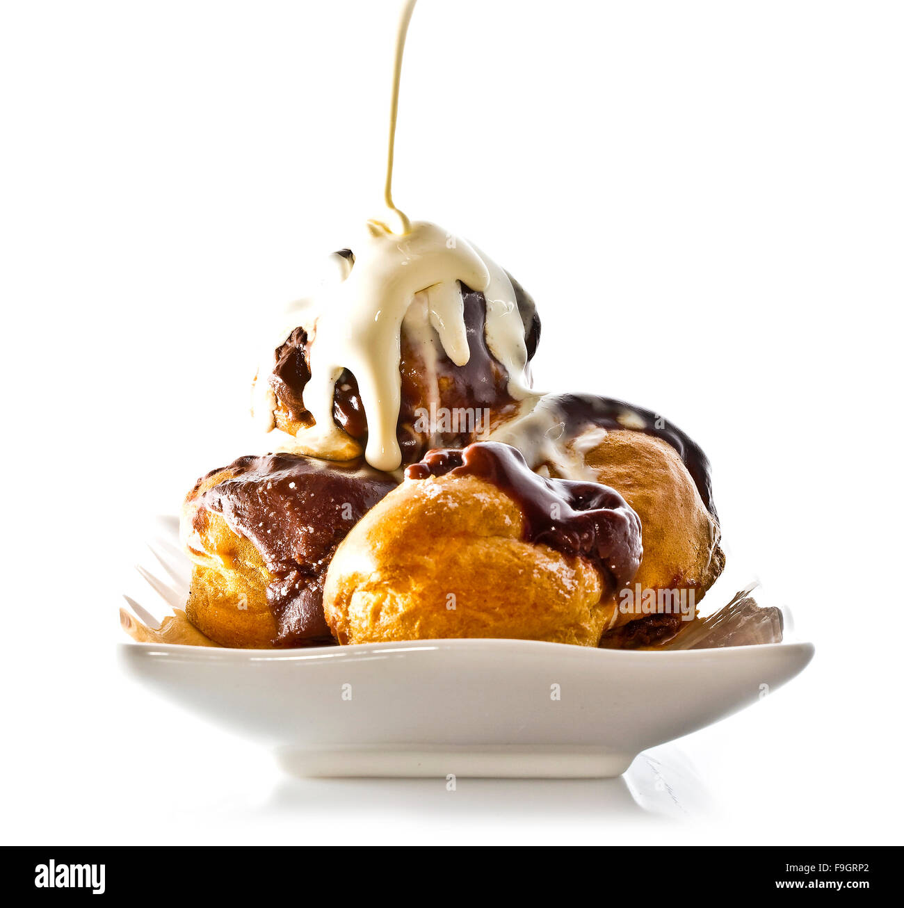 Profiteroles with hot chocolate and cream on white plate Stock Photo