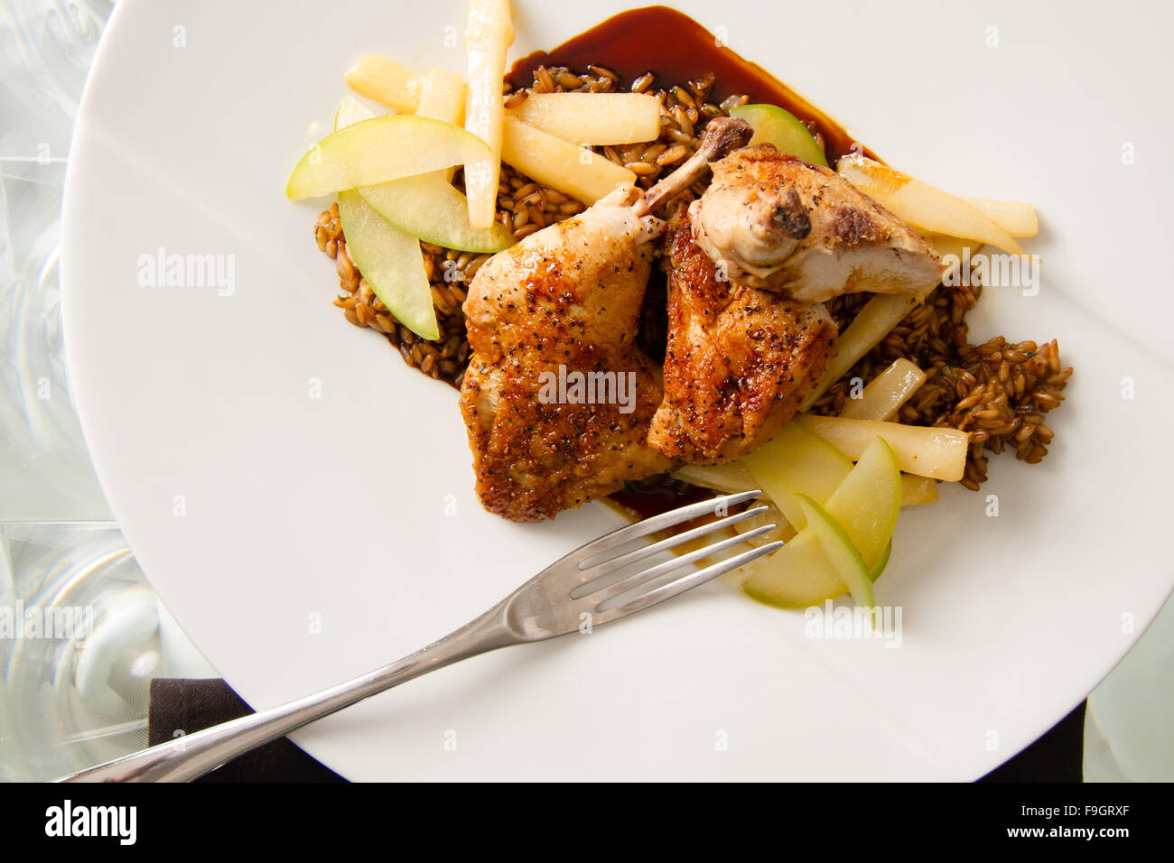 Roasted cornish game hen with toasted rye berries, compressed apple, caramelized salsify, and chartreuse jus Stock Photo