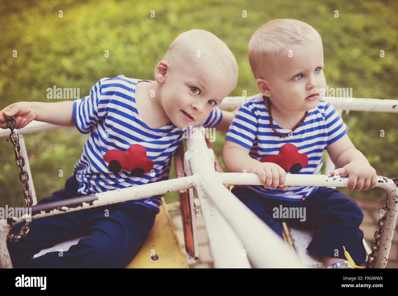 Two cute little boys on an old carousel. Stock Photo