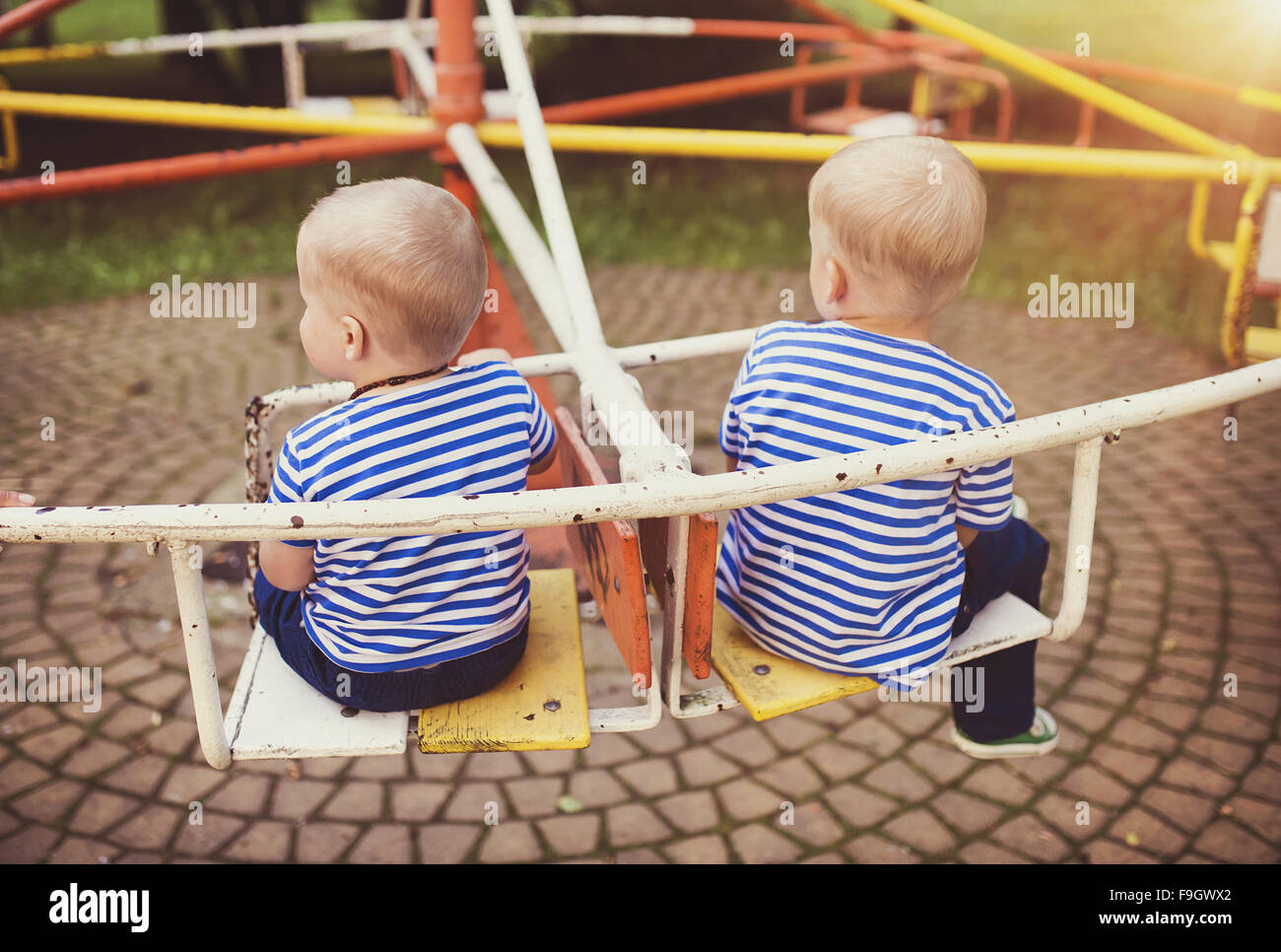 Two cute little boys on an old carousel. Stock Photo