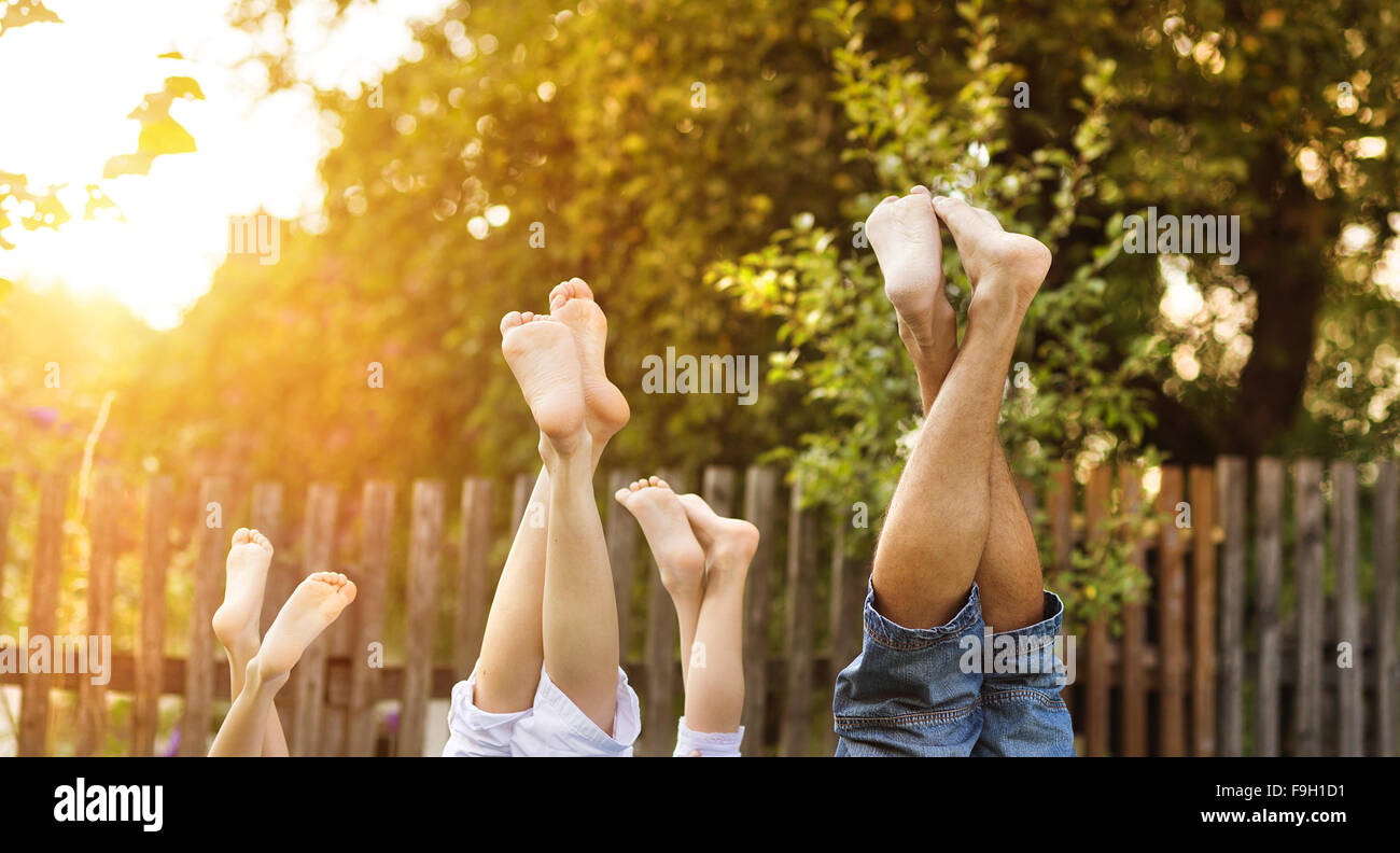 Happy young family showing legs outside in green nature. Stock Photo
