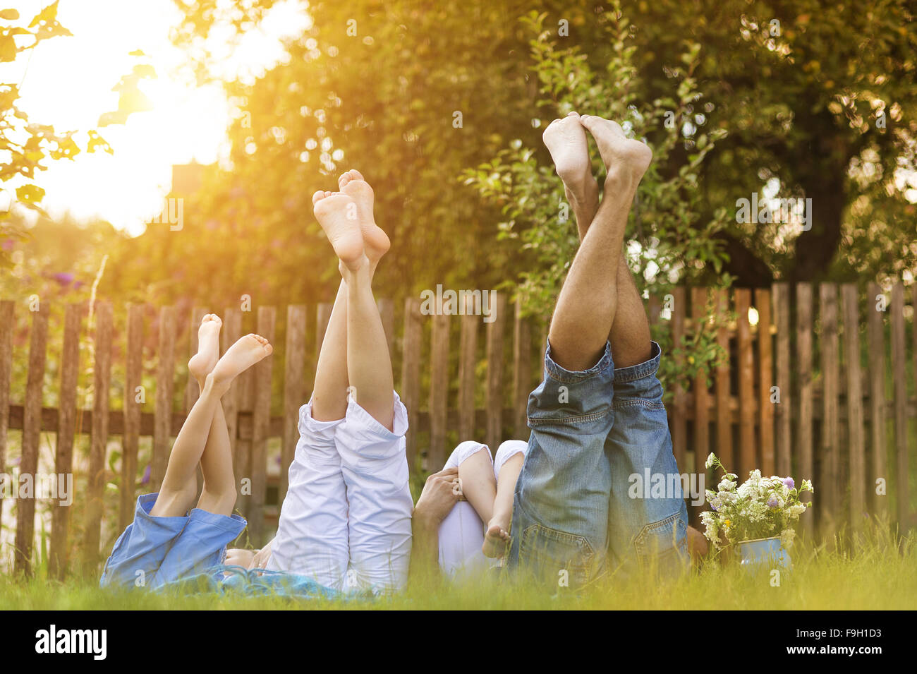 Happy young family showing legs outside in green nature. Stock Photo