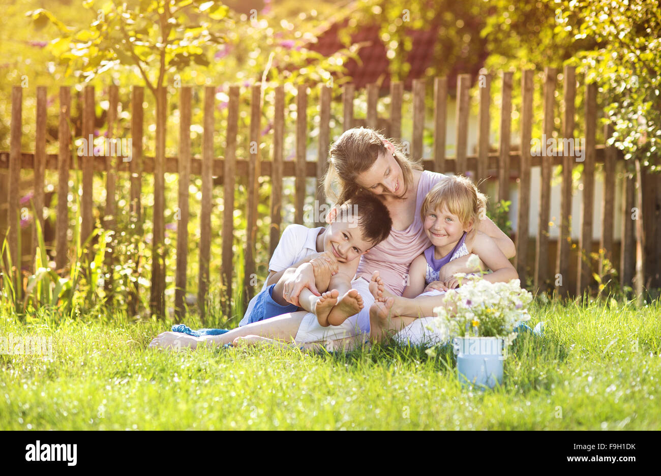 Happy mother with her children spending time together outside in green nature. Stock Photo