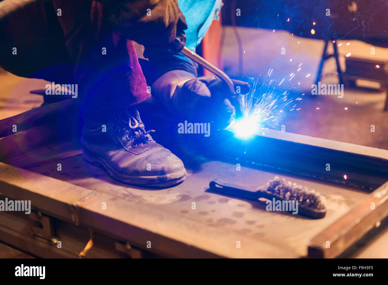 Young man with protective mask welding in a factory Stock Photo