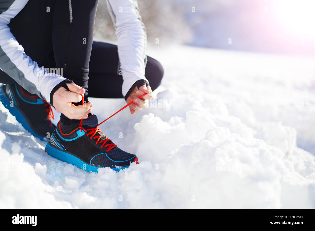 Legs of young sportsman jogging outside in a winter park Stock Photo
