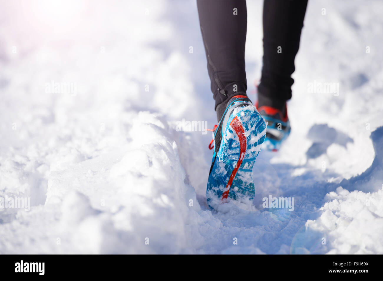 Legs of young sportsman jogging outside in a winter park Stock Photo