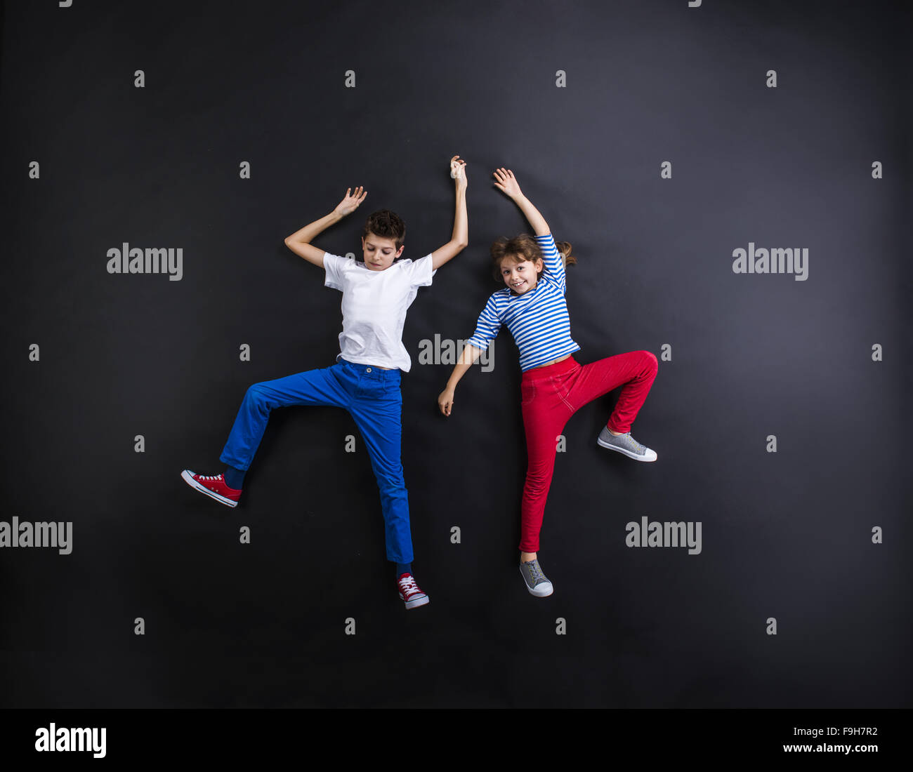 Playful young siblings laughing and having fun together. Studio shot on ...