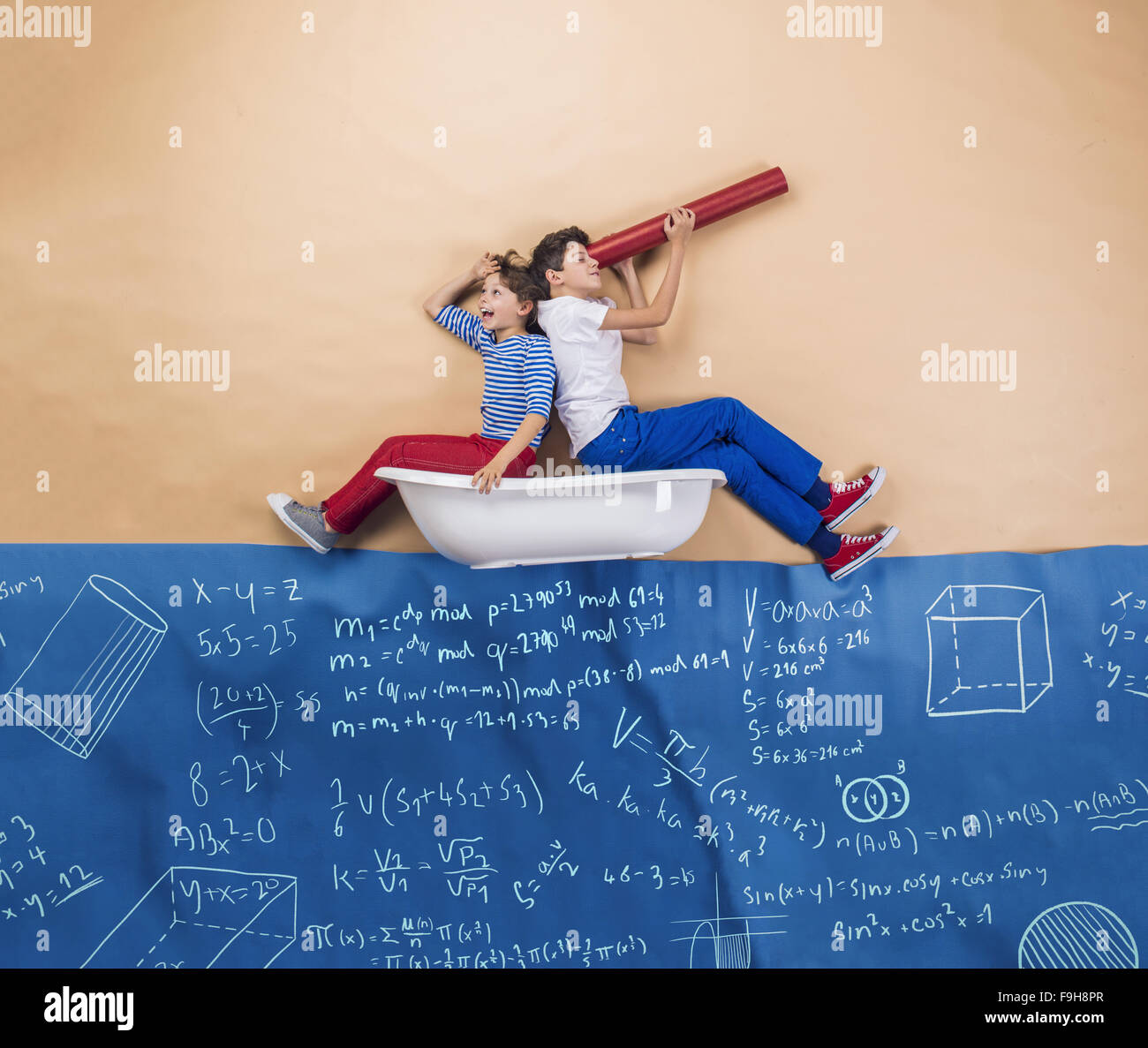 Joyful schoolkids as sailors on the sea. Studio shot on a beige background. Stock Photo