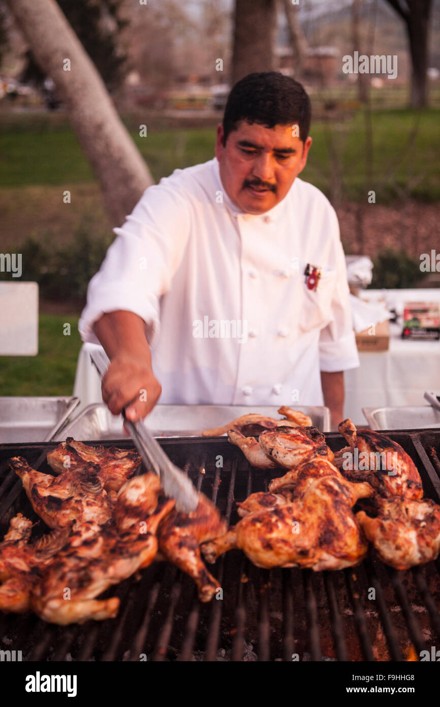 cook flips chicken grilling, BBQ Bootcamp, Alisal Guest Ranch, Solvang, California Stock Photo