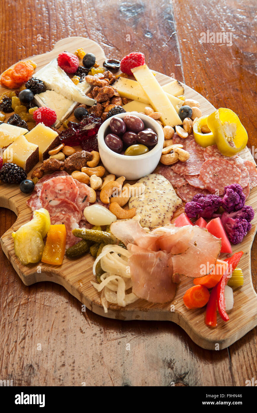 pig-shaped charcuterie board with cheeses, meats, pickled vegetables,  jam, nuts, fruits, olives and crostini, Succulent Cafe Stock Photo