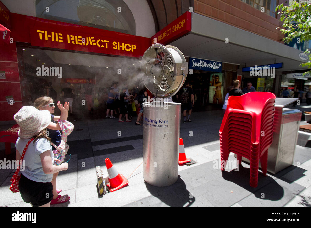 Adelaide Australia. 17th December 2015.People cool off from the oppressive heat in front of fans spraying cool mist during a heatwave in Adelaide town centre as temperatures climb to 43 degrees celsius Credit:  amer ghazzal/Alamy Live News Stock Photo