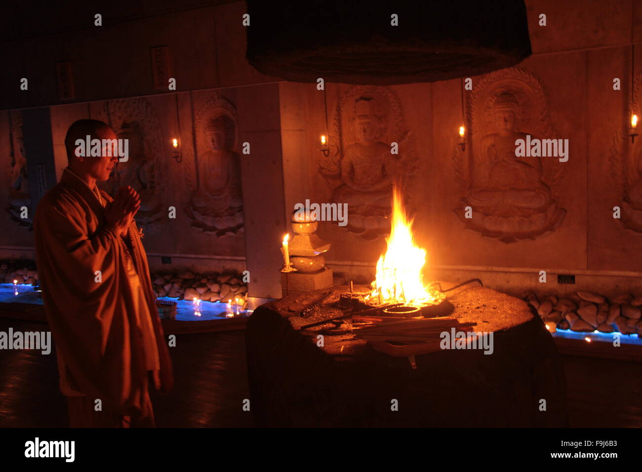 Buddhist monk praying before a fire Stock Photo Alamy