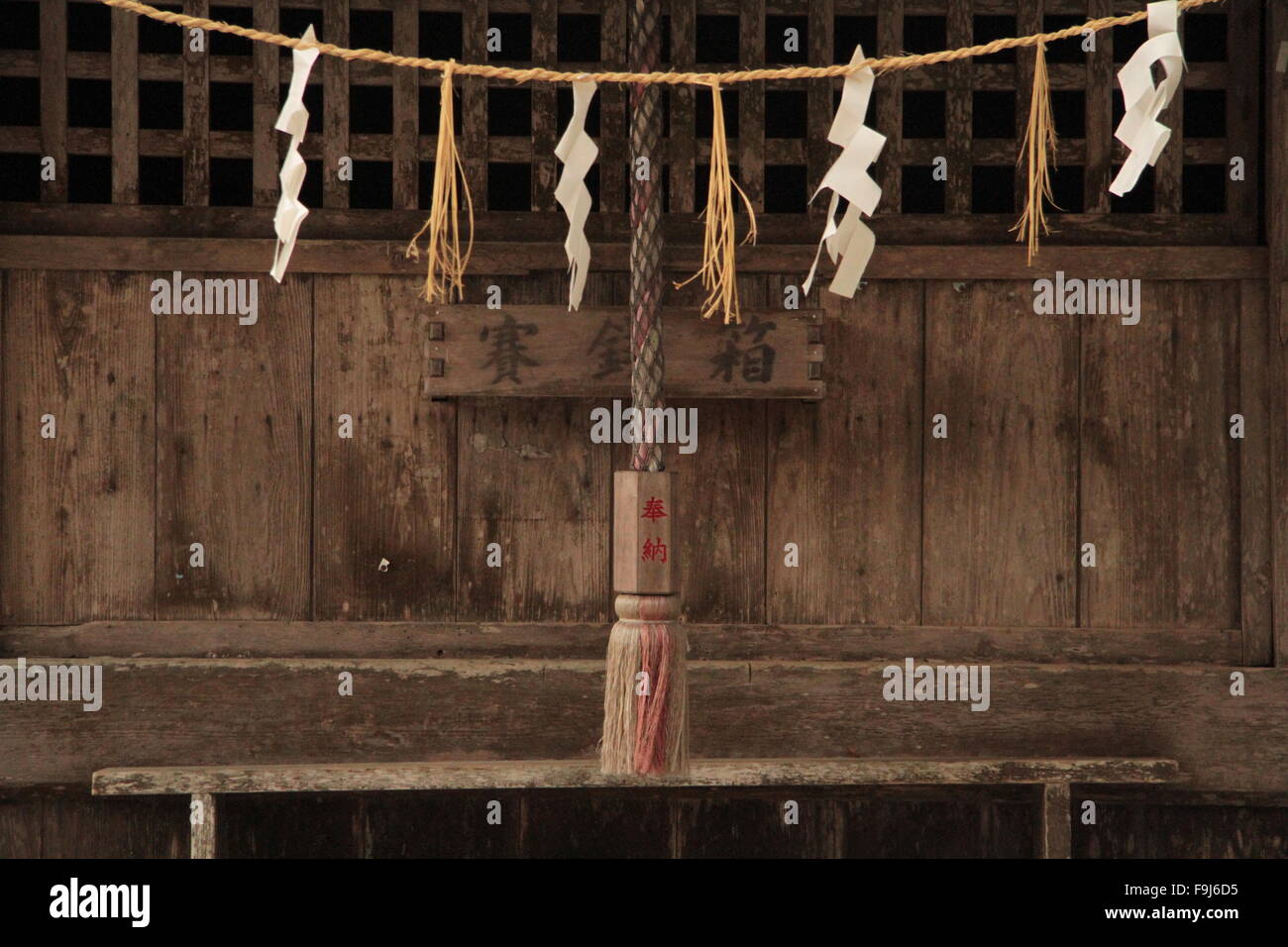 wooden door of shrine with rope and hangings Stock Photo