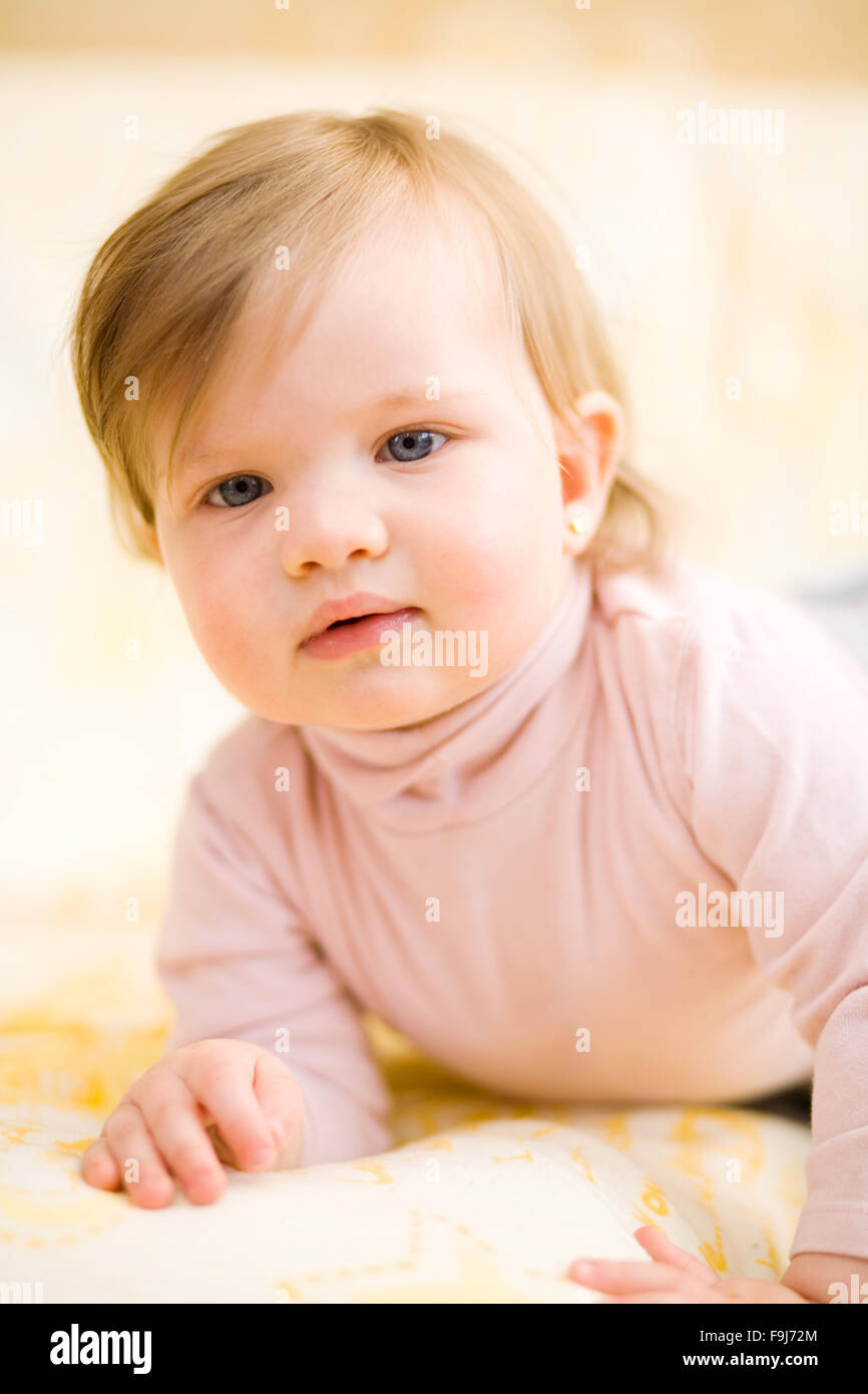 Baby girl lying on a bedspread Stock Photo Alamy