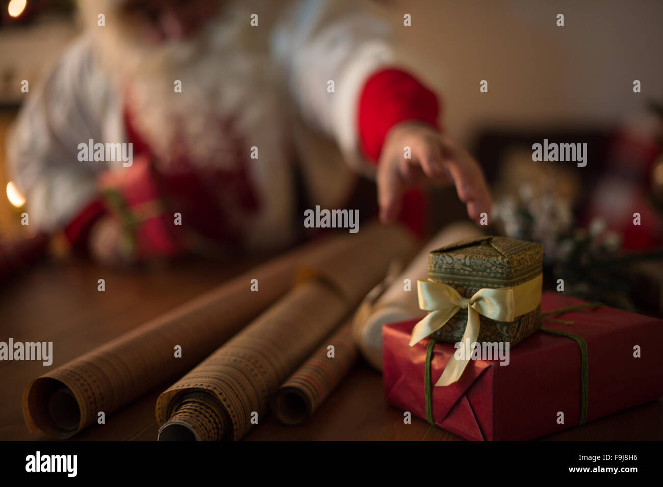 https://c8.alamy.com/comp/F9J8H6/santa-claus-at-home-wrapping-christmas-gifts-F9J8H6.jpg