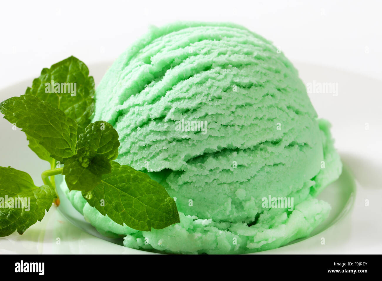 Scoop of green ice cream on plate Stock Photo