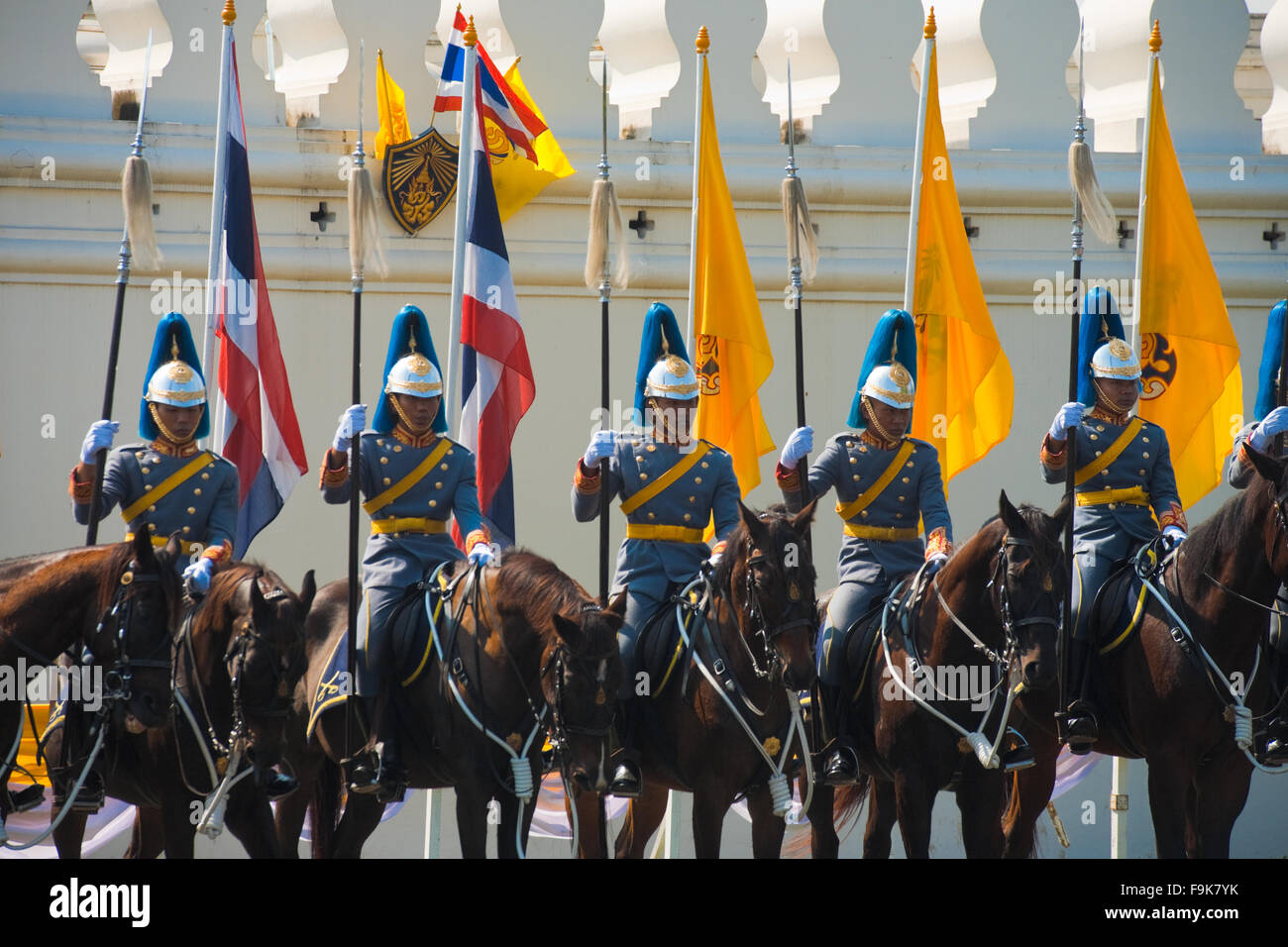 Thai Royal Mounted Guards on horses holding flags stand in formation awaiting the King at his birthday parade National Palace Stock Photo