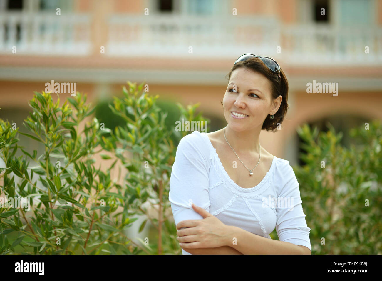 Smiling young woman in green park Stock Photo - Alamy