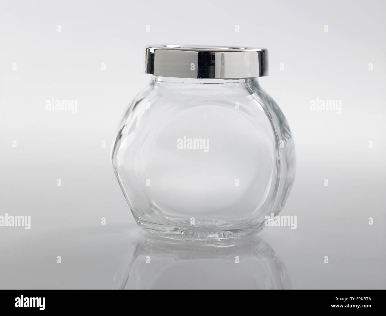 Glass jar for condiment with lid on white background Stock Photo