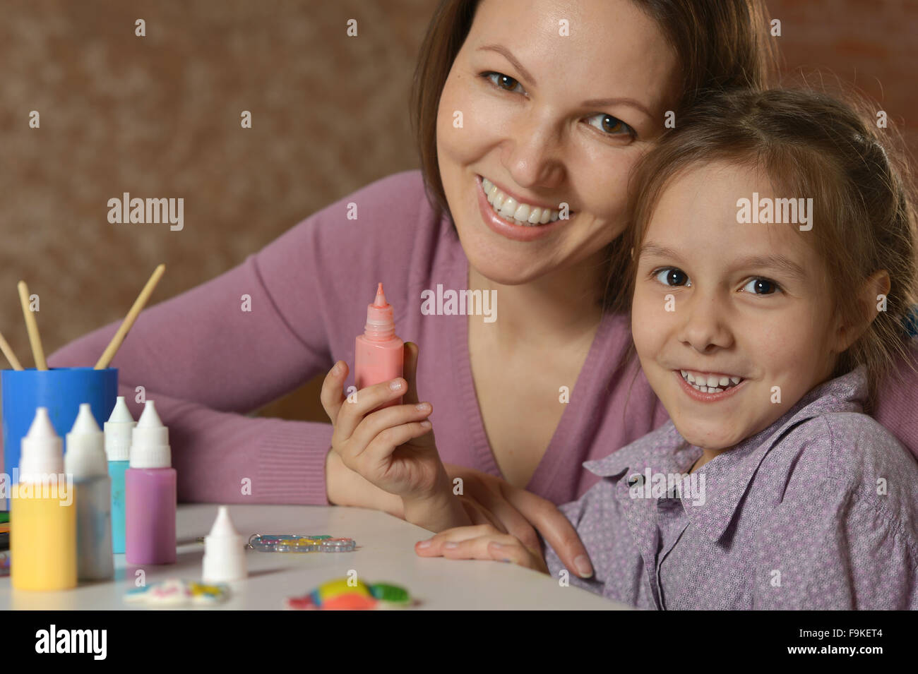 Little girl painting with her mother Stock Photo - Alamy