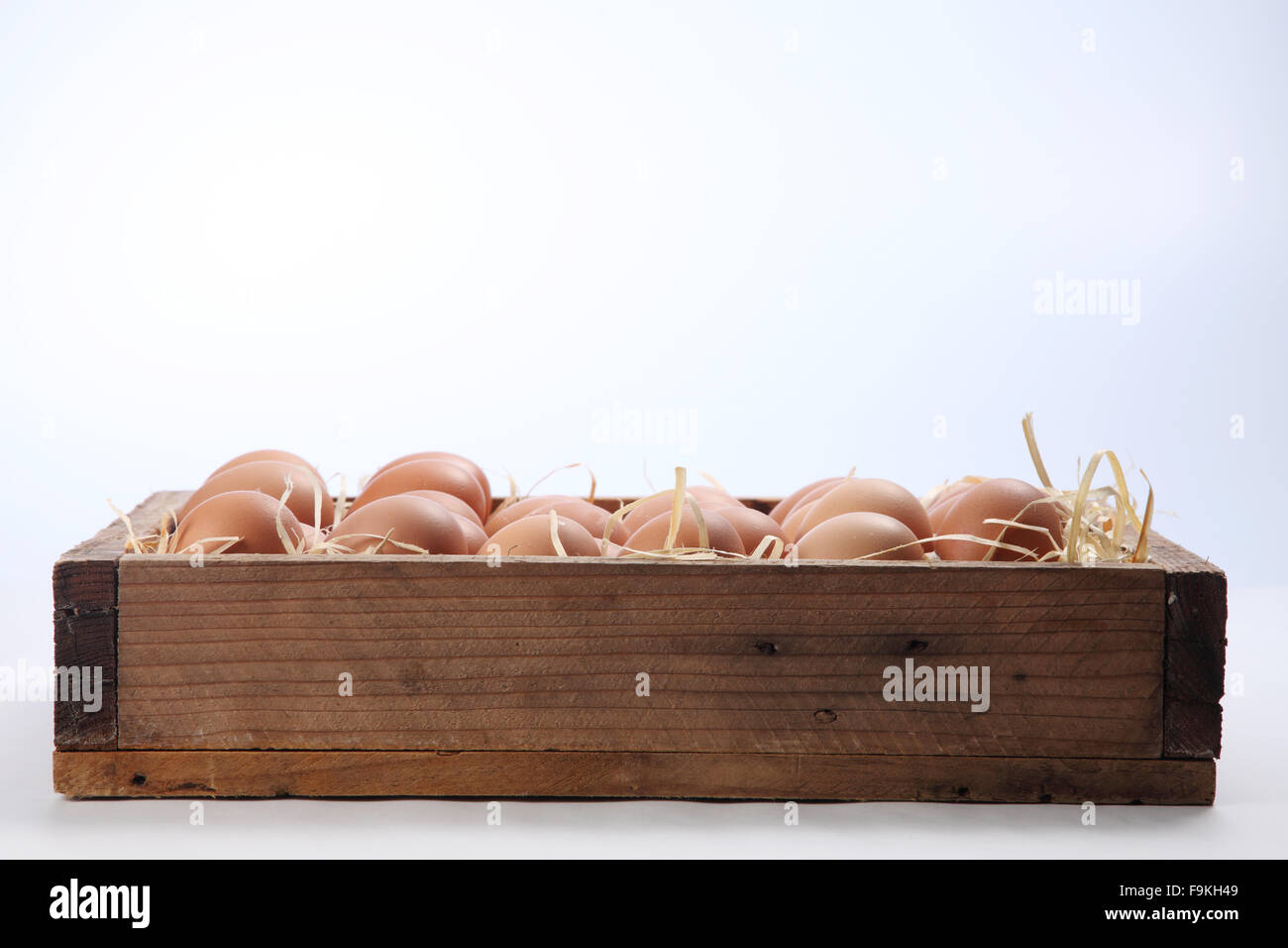 bunch of fresh brown eggs and some straw in a wooden crate Stock Photo ...