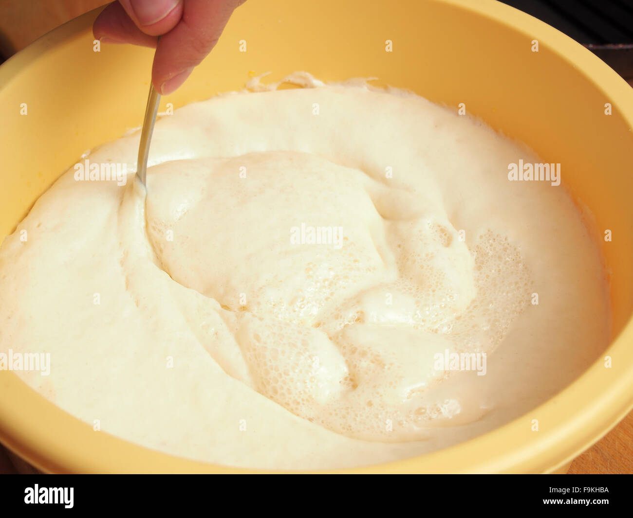 Mixing batter after rising. Making yeast pancakes (crepes Stock Photo