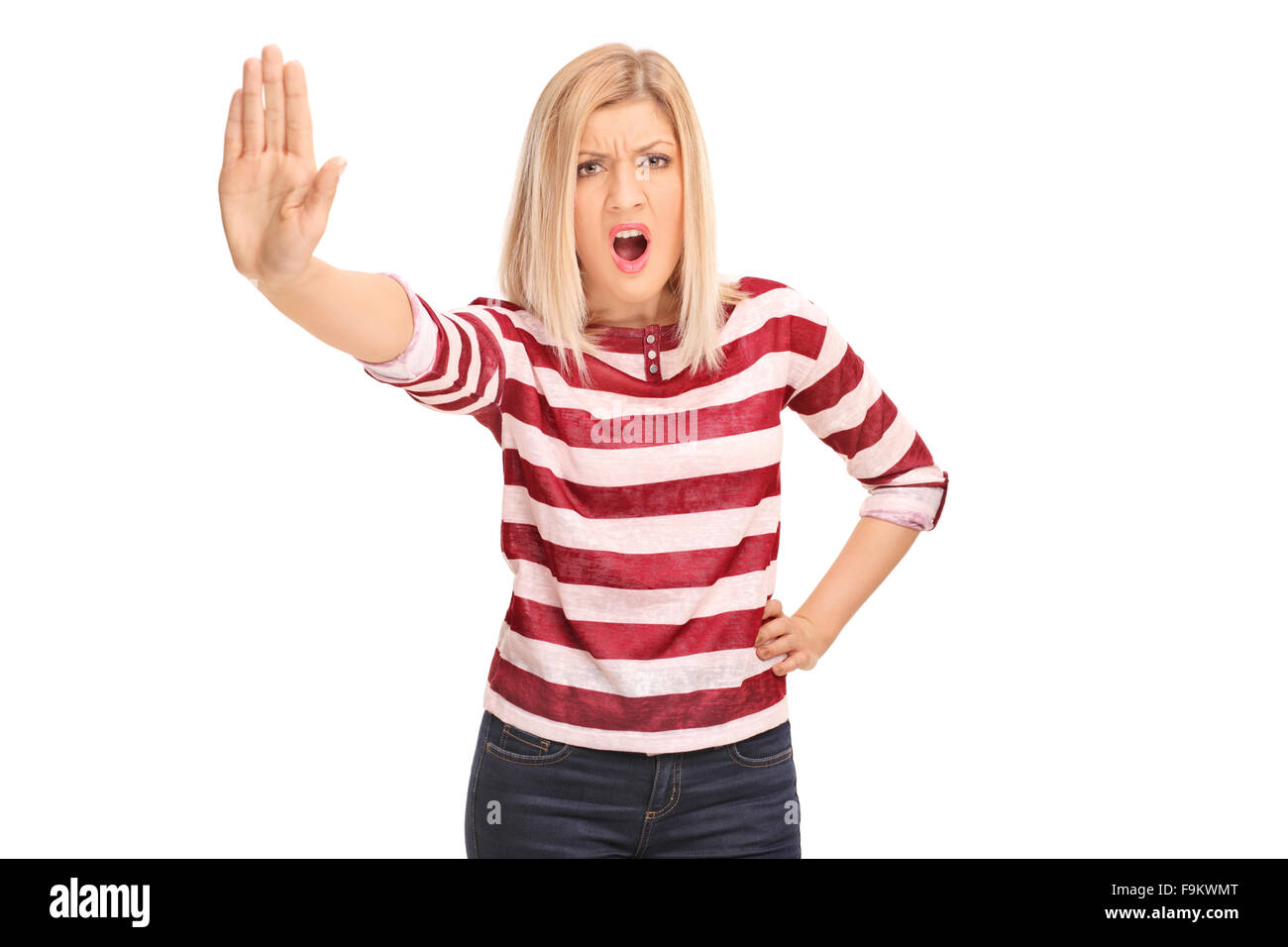 Displeased woman making a stop sign with her hand and looking at the camera isolated on white background Stock Photo
