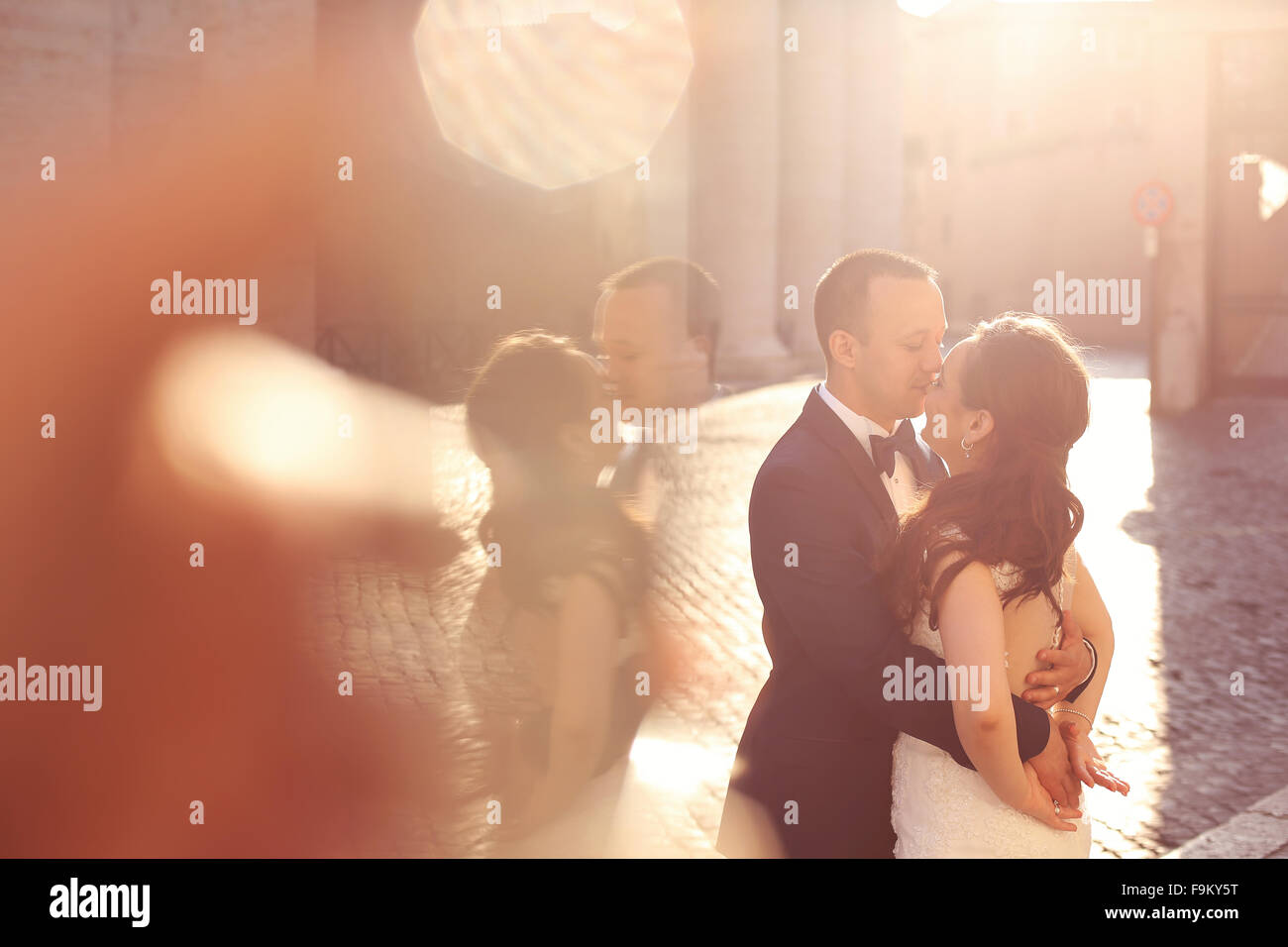 Beautiful bridal couple embracing and kissing near columns Stock Photo ...