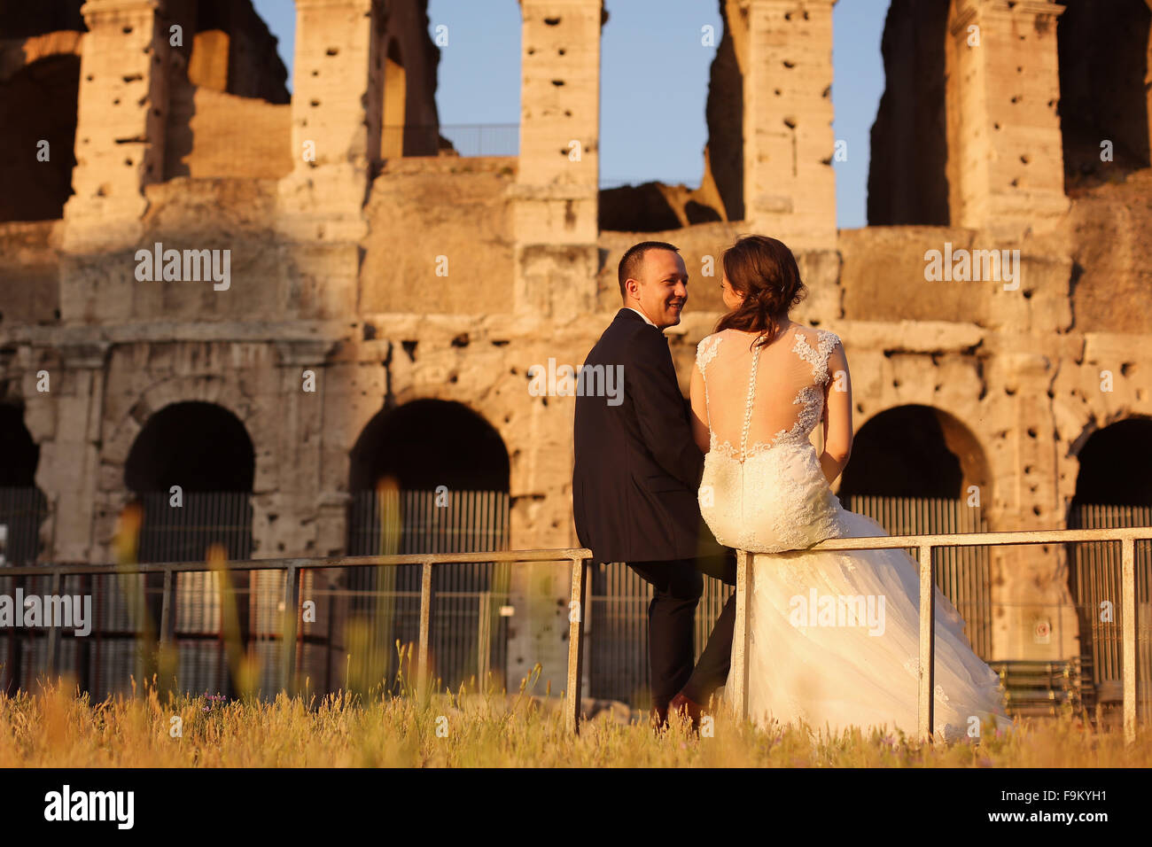 Beautiful bridal couple relaxing near Colosseum in Rome Stock Photo