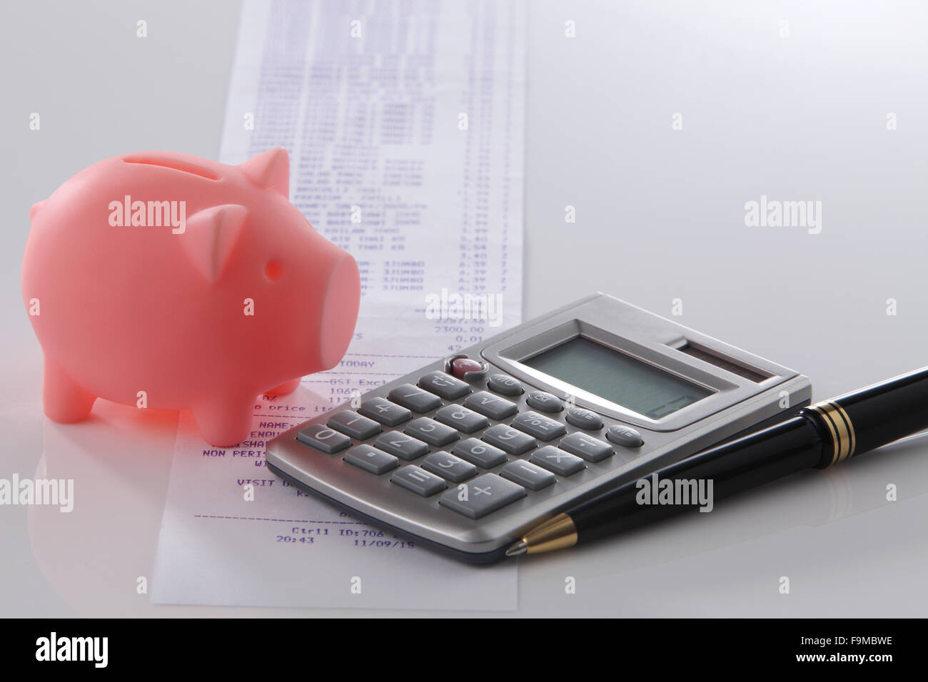 Piggy bank with calculator and receipt Stock Photo - Alamy