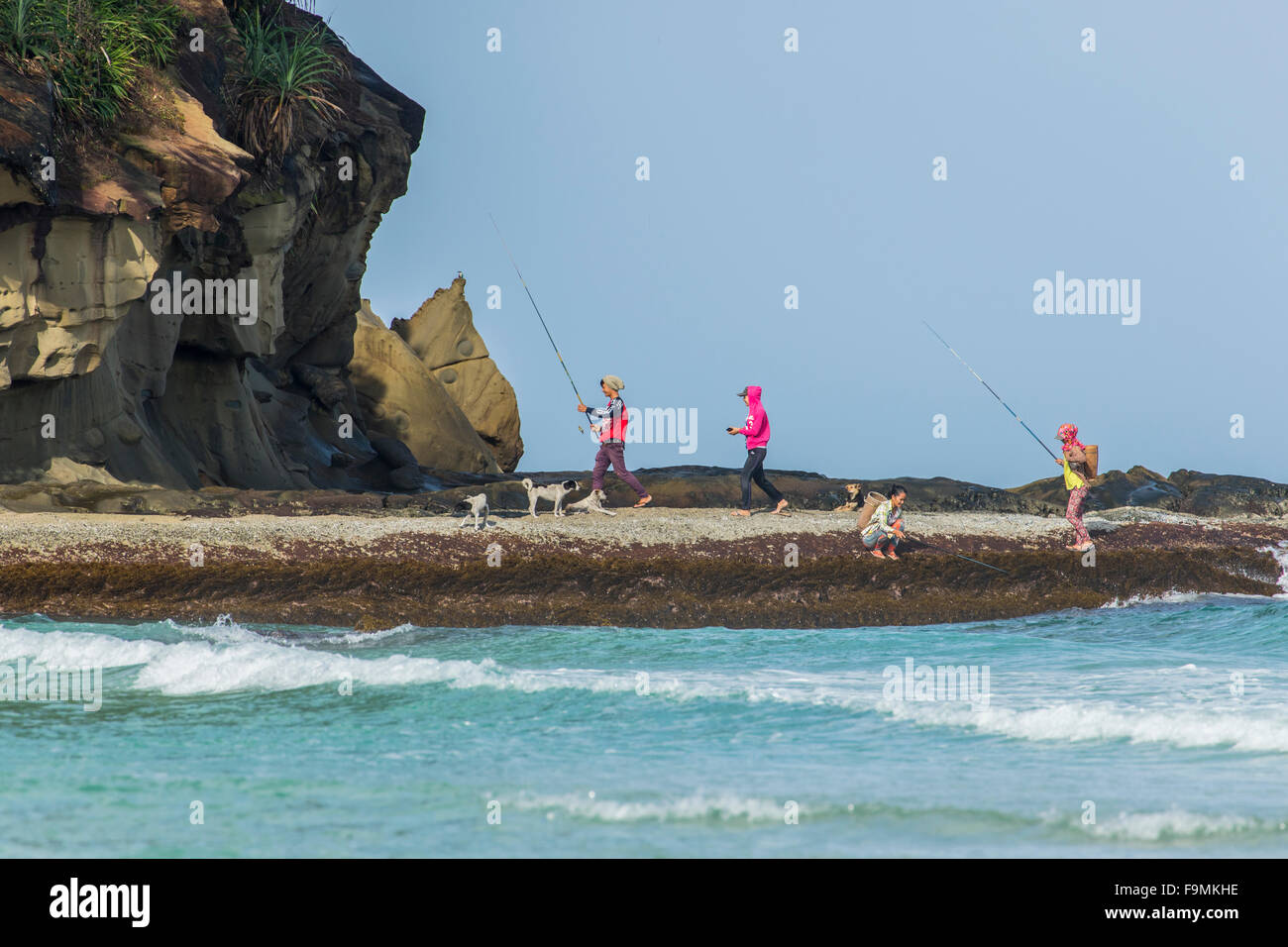 Anglers fishing from rocks on Tip of Borneo beach Sabah East Malaysia Island of Borneo Stock Photo