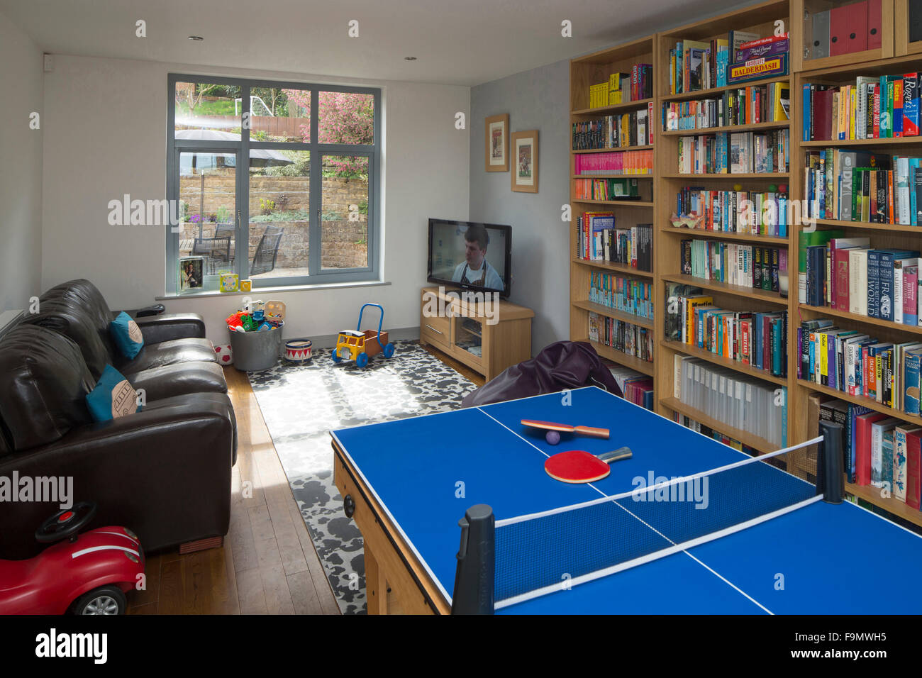 Playroom showing table tennis table, bookcases and toys in a moden family home. Stock Photo