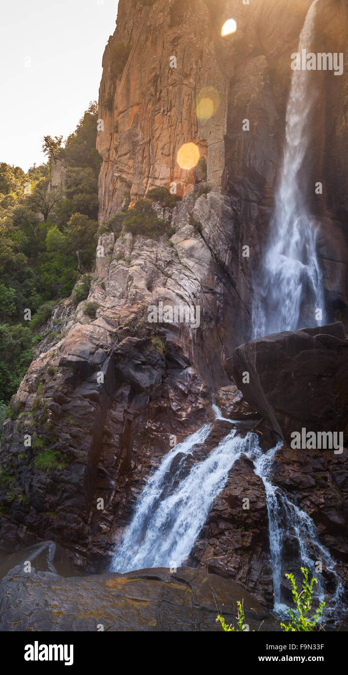 Natural vertical landscape, waterfall in South part of Corsica island, France. Lens flare photo effect Stock Photo