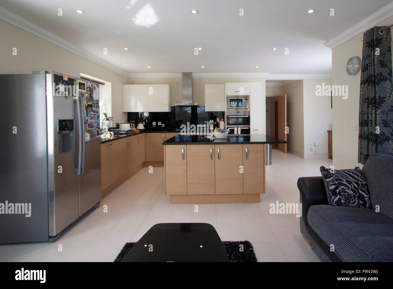 Modern kitchen with an island sofa and fridge Stock Photo Alamy